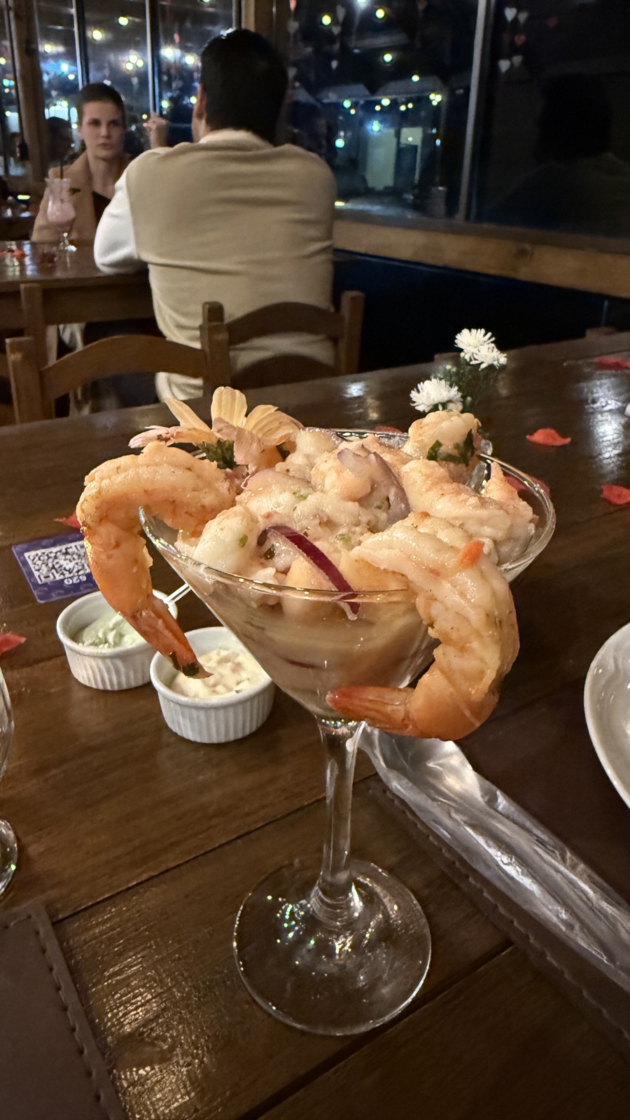 A shrimp cocktail in a martini glass at a candlelit dinner out