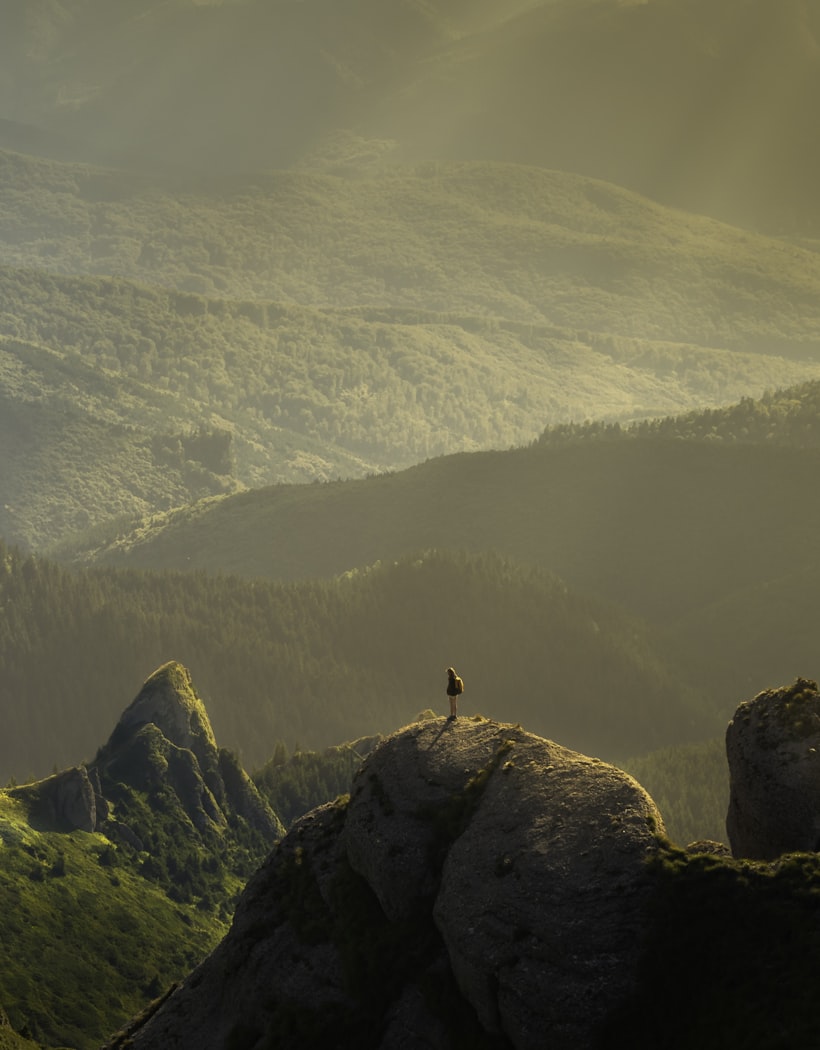 A lone hiker on a golden mountain ridge