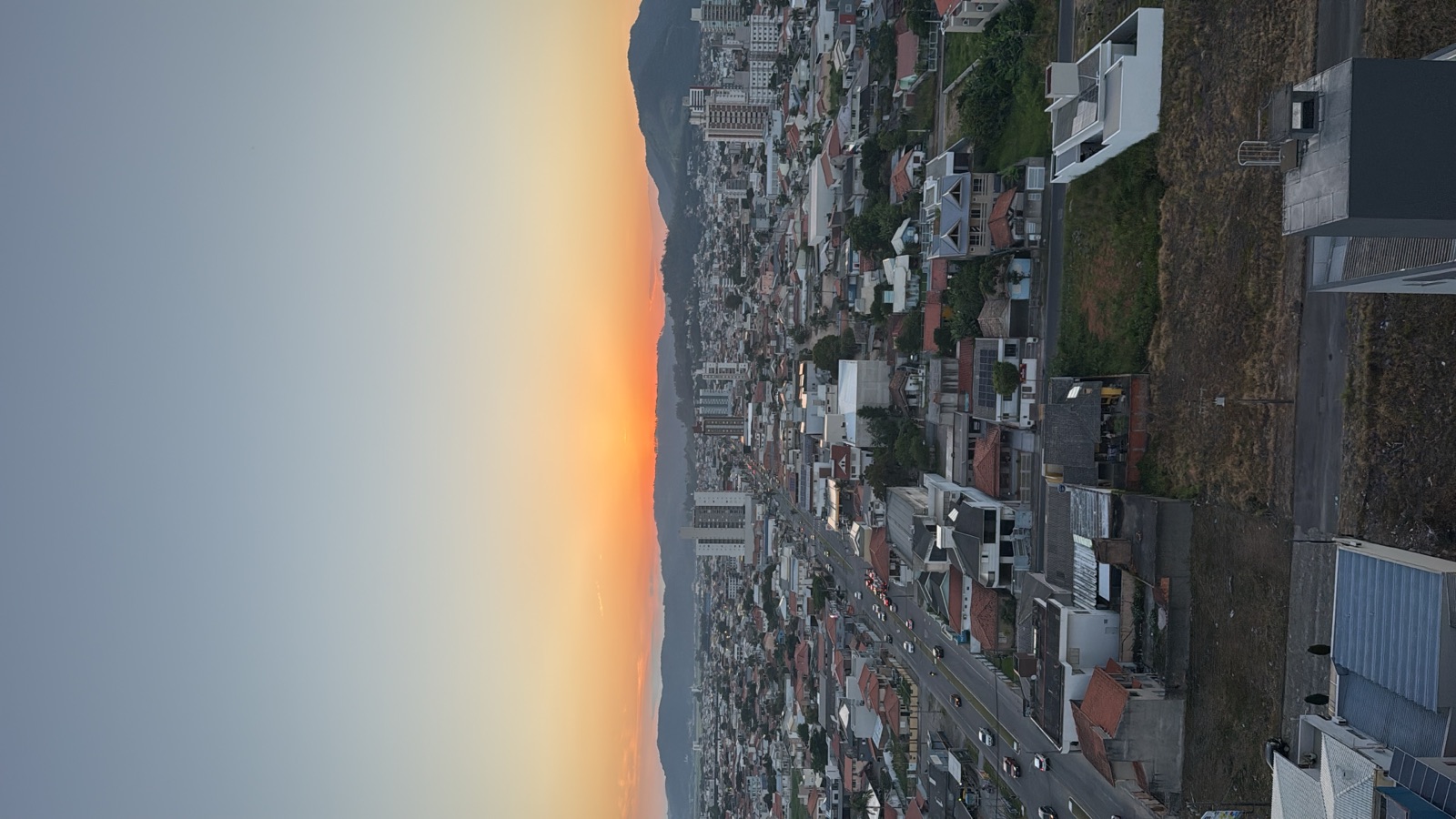 A whole city glowing under a golden-hour sky, seen from above